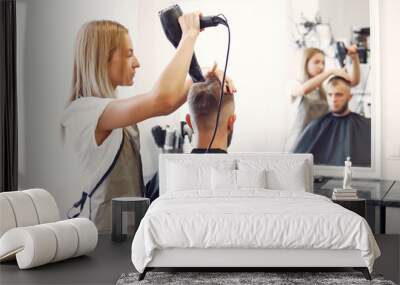 Man with a beard. Hairdresser with a client. Woman drying man's hair Wall mural