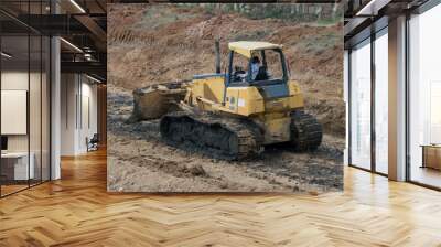 Yellow bulldozer moving dirt at a construction site Wall mural