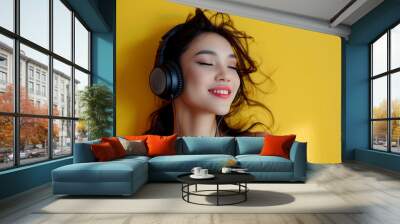 woman wearing headphones against yellow background Wall mural