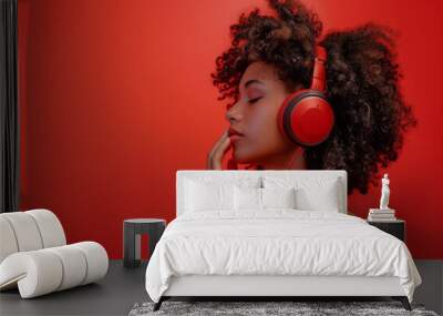 woman with curly hair listening to red headphones Wall mural