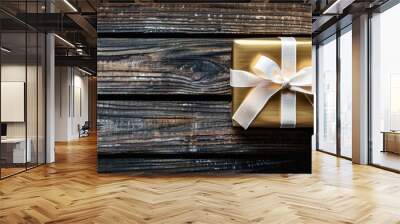 Gold gift box with white ribbon on a wooden background, elegant and classic Wall mural