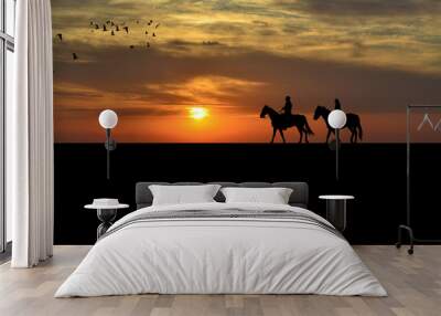 A couple on a horse riders at sunset Wall mural