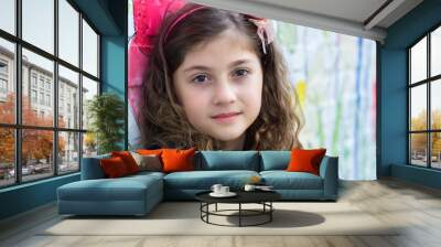 Portrait of a beautiful little girl smiling, against colorful wall Wall mural