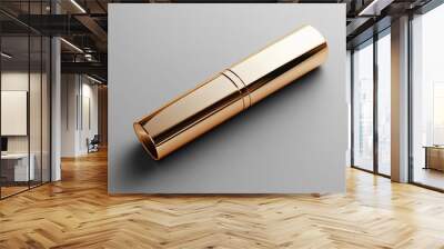 A sleek, shiny gold tube object with a polished surface, resembling a luxurious accessory or container. Wall mural