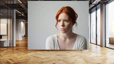 Portrait of a red hair woman with a deep sad expression  against white background, background image, AI generated Wall mural