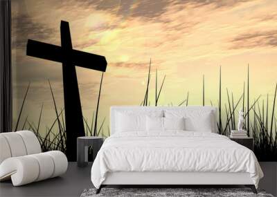 Black cross in grass at sunset Wall mural