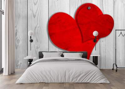 Conceptual two red old paper vintage hearts nailed on white wood Wall mural