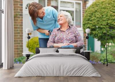 carer with senior woman in wheelchair Wall mural