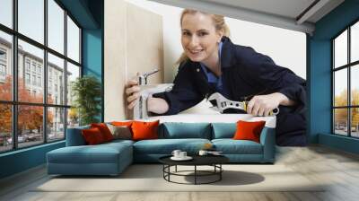 Female Plumber Working On Sink Using Wrench Wall mural