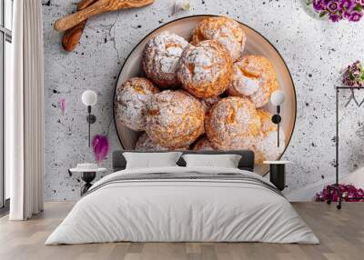 Fresh baked choux pastry cakes with powdered sugar Wall mural