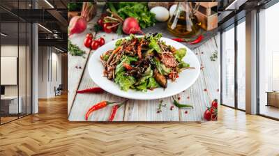 Warm salad with beef vegetables on wooden table Wall mural