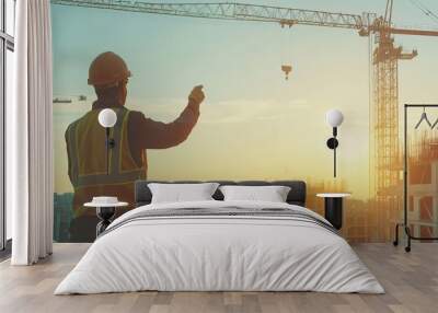 construction worker in a hard hat operating a crane at a busy building site, copy space Wall mural