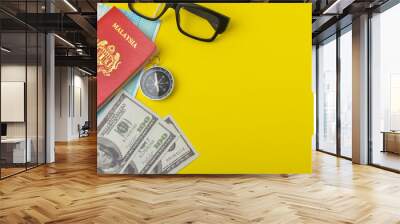 Passport with face mask, banknotes, compass and spectacles on yellow background. Travel and health concept. Wall mural