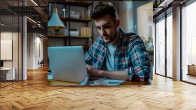 A young businessman working on his laptop, a young freelancer working with his laptop Wall mural