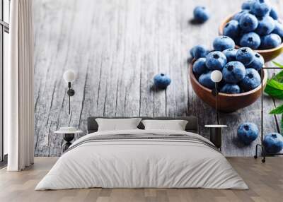 Bowl of fresh blueberries on blue rustic wooden table closeup. Wall mural