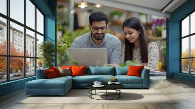 Indian asian young CEO businessman working with female colleague in the office using laptop computer, Generative AI Wall mural