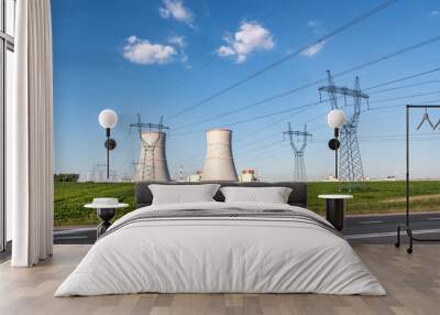 Cooling towers of nuclear power plant with high voltage electric pylon towers against the blue sky Wall mural