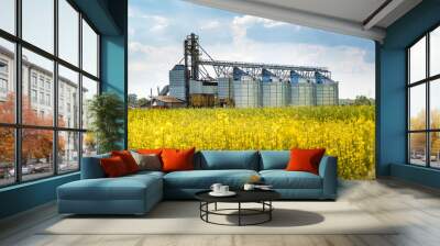 Modern Granary elevator near rapeseed field. Silver silos on agro-processing and manufacturing plant for processing drying cleaning and storage of agricultural products. seed cleaning line Wall mural