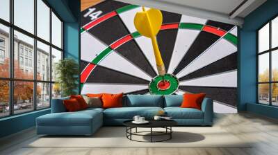 Red and yellow dart arrows hitting in the target center of dartboard. Success hitting target aim goal achievement concept Wall mural