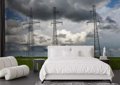 Silhouette of the high voltage electric pylon towers on the background of beautiful clouds Wall mural