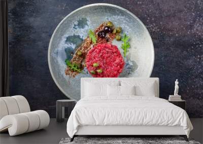 Modern style gourmet tartar raw from beef filet with capers and amarena cherry served with truffle cream and lettuce as top view on a Nordic design plate with copy space Wall mural