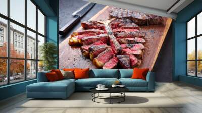 Modern style traditional barbecue dry aged wagyu porterhouse beef steak bistecca alla Fiorentina sliced and served as close-up on a wooden design board Wall mural