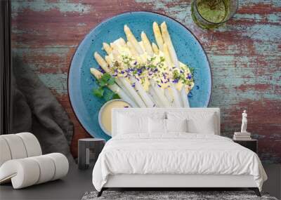 Modern style traditional steamed white asparagus garnished with sauce hollandaise and herbs served as top view on a design plate Wall mural