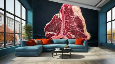 Raw dry aged wagyu porterhouse beef steak with large fillet piece as closeup on a black burnt wooden board with copy space Wall mural