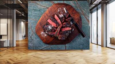 Traditional barbecue dry aged wagyu porterhouse beef steak bistecca alla Fiorentina sliced with salt and pepper served as top view on a wooden design board with a Japanese knife Wall mural