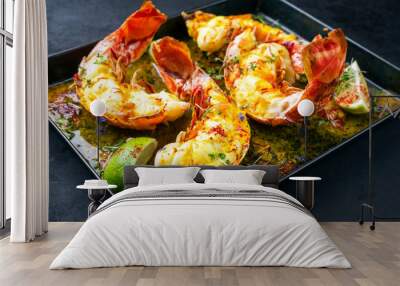 Traditional barbecue spiny lobster tail sliced and offered with saffron lemon sauce as closeup in a metal try Wall mural