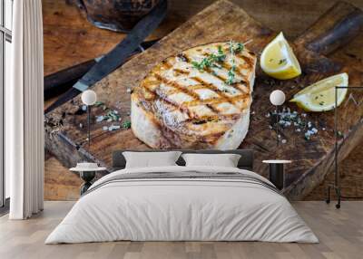 Traditional barbecue swordfish steak with salt and lemon served as close-up on an old rustic wooden board Wall mural