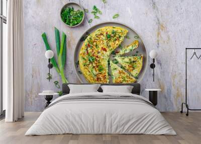 Traditional Italian vegetable frittata with zucchini, spring onion and cheese served as top view on Nordic design plate with text space Wall mural