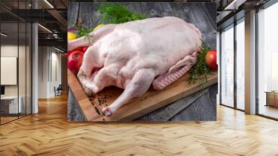 Traditional raw Christmas goose with vegetable and fruits offered on a wooden cutting board Wall mural