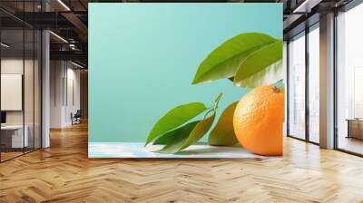 A fresh juicy clementine with leaves on top isolated pastel background Copy space Wall mural