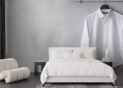 A hanger displaying a white long sleeved men s shirt and two gray suits provides a copy space image Wall mural