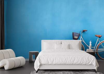 A high-quality photo of a bicycle is positioned against a blue wall, with empty space available Wall mural