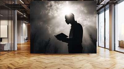 A man holds a Bible prays in black and white with a light flare Wall mural