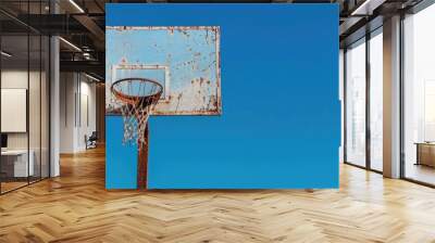 A rusty basketball hoop outdoors under a clear blue sky with no net and a blank area for text or copy space image on the side Wall mural