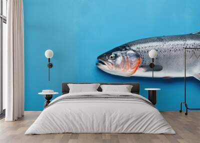 A top view of a blue background with a pattern of raw trout steak creating a copy space image Wall mural