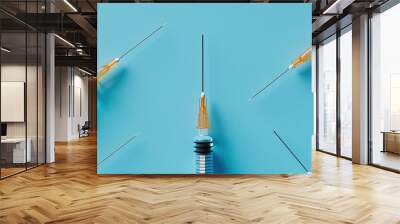 Aerial view of syringes with needles on a blue background emphasizing copy space image Depicting the concept of injection treatment Wall mural