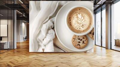 Enjoy a latte and cookies on a plate placed on an old book under a notebook against a white table background creating a cozy and relaxing atmosphere with a copy space image Wall mural