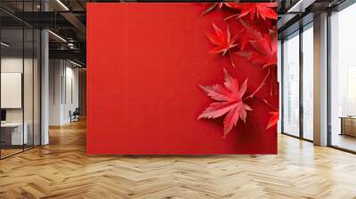 Maple leaves adorned on a red background with copy space image Wall mural