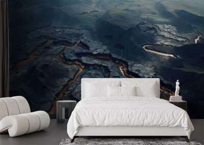 Open pit ore mining. Photo of a pit for mining ore from the air. A string of roads in the mountains dug by man. Wall mural