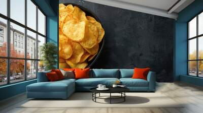 Potato and paprika chips in a bowl served with mustard and salt on a dark textured background ideal for a copy space image Wall mural