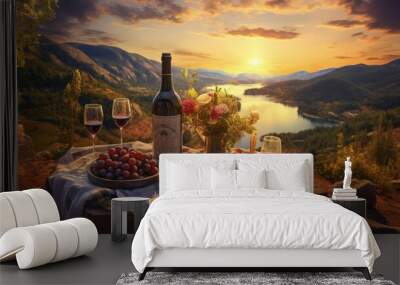 Romantic picnic on the mountain with river and sunset on background. Bottle of wine, glasses and dessert. Wall mural