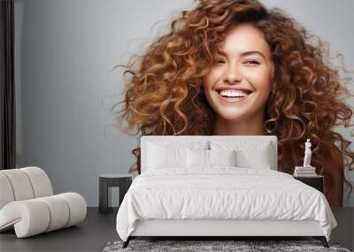 Smiling girl with curly hair joyfully White studio background Wall mural