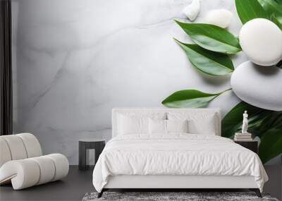 The background concept for a spa is depicted by the presence of white stones, a towel, and green plant leaves on a marble background, providing room for customization. This concept represents body Wall mural