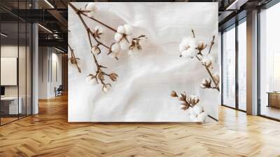 Top view of a lovely cotton branch on white fabric with copy space image displaying delicate white flowers on a light cotton background emphasizing eco friendly textiles Wall mural