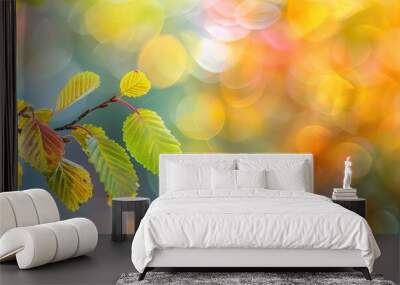 Vibrant autumn backdrop featuring a branch with yellow green leaves against a blurred backdrop of yellow green and red leaves with clear copy space image Wall mural