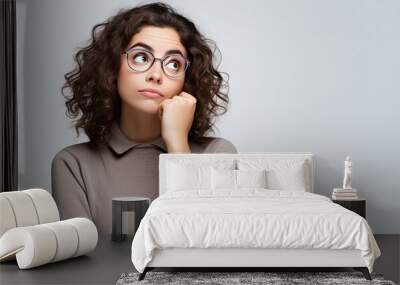 Young woman looking away in confusion with white background Wall mural